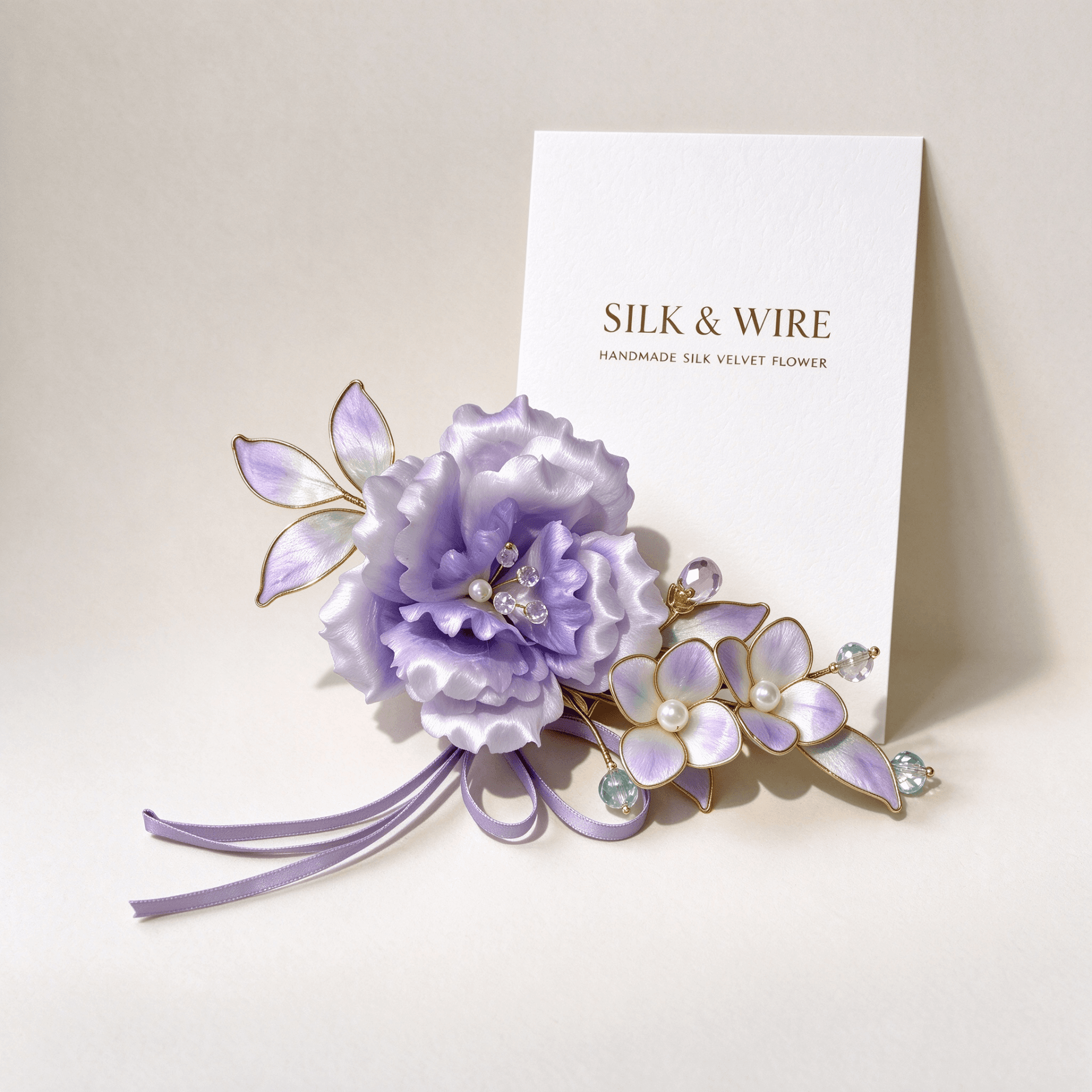 Lavender handmade silk velvet peony brooch beside an ivory brand card with "Silk & Wire"